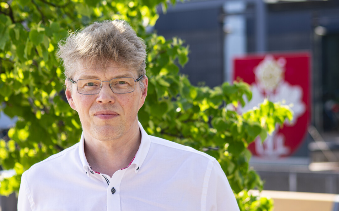 Muuramen kunnanjohtaja Jarkko Määttänen hymyilee Muuramen virastotalon edessä kesällä 2023.