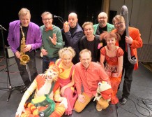 Kuvassa on kymmenen esiintyjää, Loiskis-orkesteri ja Katti Matikainen-hahmo.