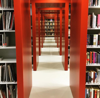 Näkymä Muuramen kirjastosta kirjahyllyjen välisestä käytävästä.